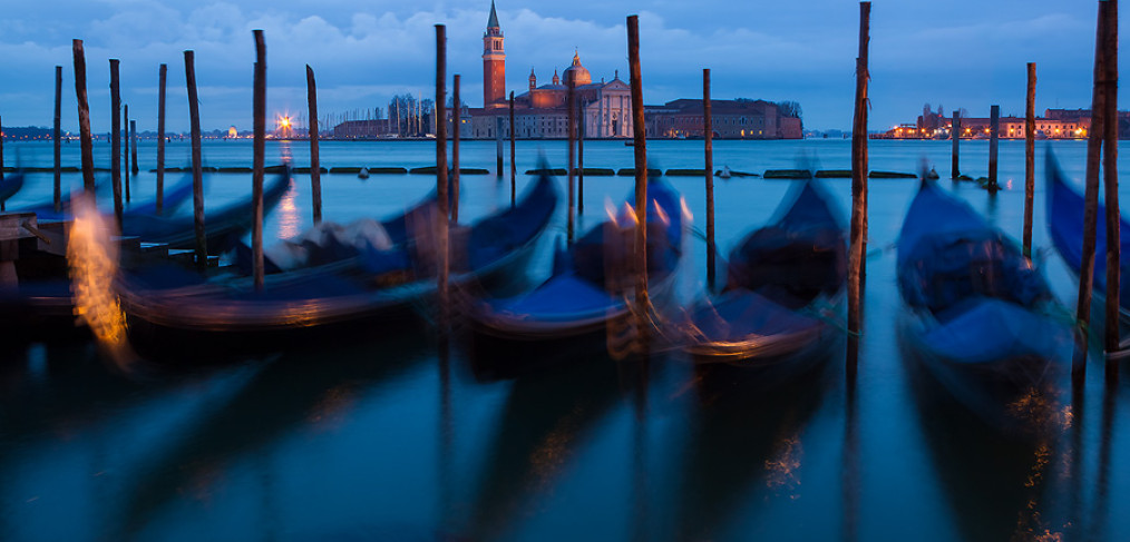 A dark and cloudy March morning in Venice. The sway of gondolas is exaggerated by long exposure. The iconic church of San Giorgio Maggiore can be seen in the backgroung.