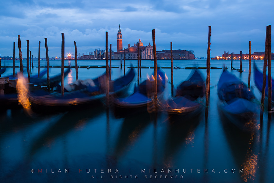 A dark and cloudy March morning in Venice. The sway of gondolas is exaggerated by long exposure. The iconic church of San Giorgio Maggiore can be seen in the backgroung.