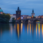 A peaceful evening without tourist boats on river Vltava, near Charles' Bridge. The town silouette from the left: Towers of Clementinum, The dome of Church of Saint Francis of Assisi, Old Town Bridge Tower and the Tower of Charles' Bathhouse