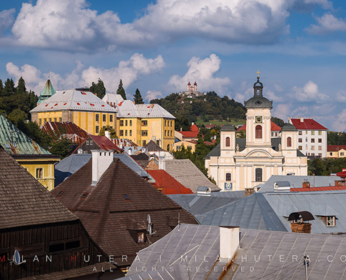 The old mining town of Banska Stiavnica is one of the most important landmarks of Slovakia and it is a part of UNESCO World Heritage Site since 1993. The mines around town were rich in silver ore and other precious metals. The town was also a home to first mining college in Europe and the first ever Technical School in the world - established in 1763. This photo depicts a late August afternoon overlooking the rooftops of the historic center of Banska Stiavnica. The metal and wooden rooftops are a necessity due to large snowfall in winter months. The hilltop Calvary, which is perhaps the town's most famous landmark, is visible in the distance.