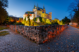 Late autumn evening at Bojnice Castle with old warm amber lighting and autumn trees
