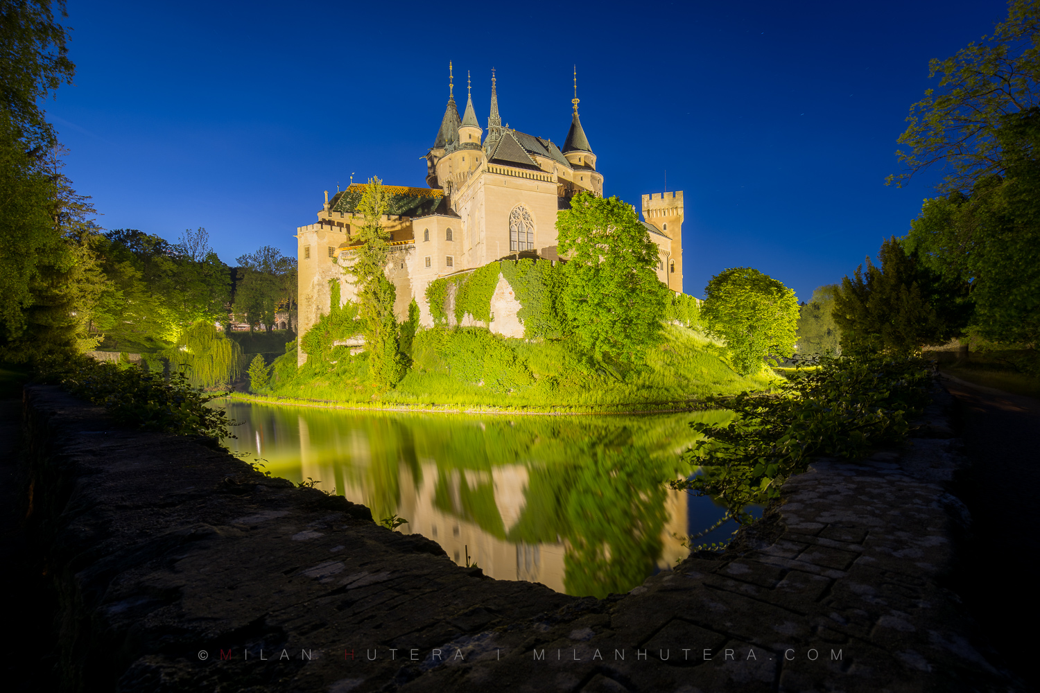 Evening view of the Bojnice Castle reflecting in the moat water