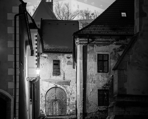Black and white photography of Farská Street in Bratislava, with the Castle in the fog.