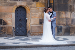 Astronomical Clock Pre-Wedding Photoshoot in Prague with an Asian couple posing by the historic door