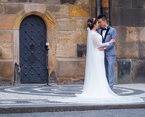 Astronomical Clock Pre-Wedding Photoshoot in Prague with an Asian couple posing by the historic door