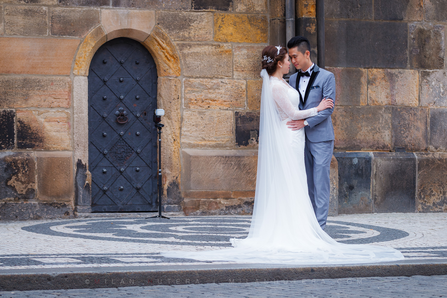 Astronomical Clock Pre-Wedding Photoshoot in Prague with an Asian couple posing by the historic door