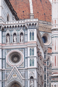 Close-up of Florence cathedral facade details with pink green and white marble panels under an overcast sky
