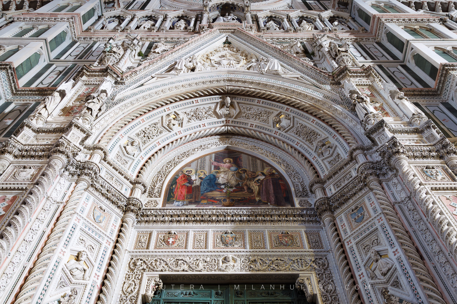 Close-up of the Florence cathedral main entrance portal and its stunning details illuminated by streetlights before dawn