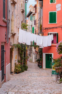 Rovinj narrow streets with colorful houses and white laundry drying between historic stone buildings