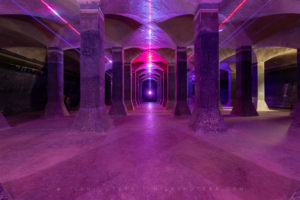 Cyberpunk-style laser light art installation reflecting on the concrete pillars and architecture inside the 1917 Žlutý kopec water reservoir.