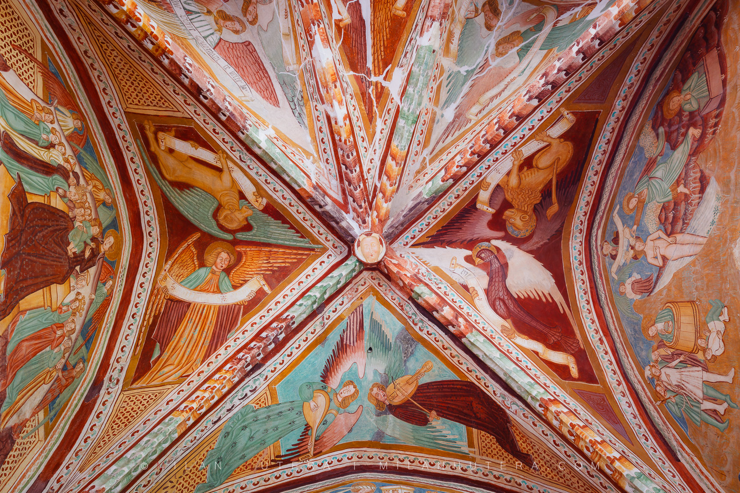 Bohinj church frescoes depicting medieval angels and symbols of evangelists painted on a Gothic ribbed vault.