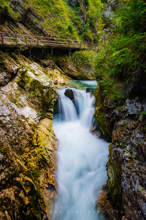 Vintgar Gorge Rapids with a wooden tourist walkway and a turquoise waterfall in Bled, Slovenia