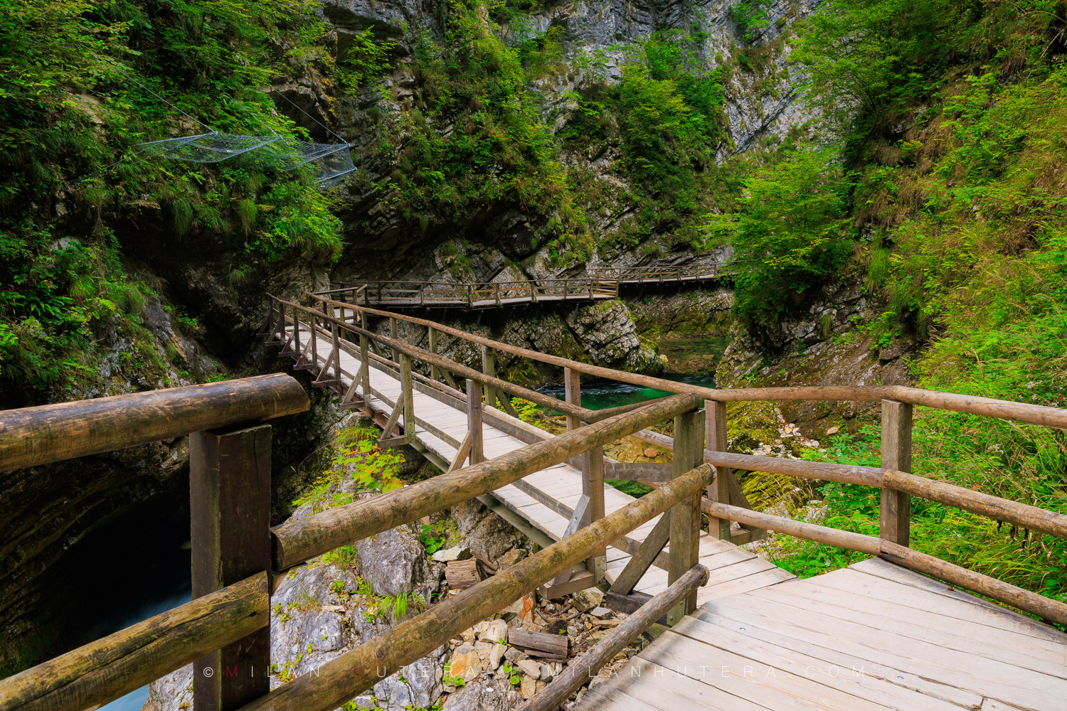 Vintgar Gorge wooden walkways winding along the steep limestone cliffs above the turquoise Radovna River in Slovenia.