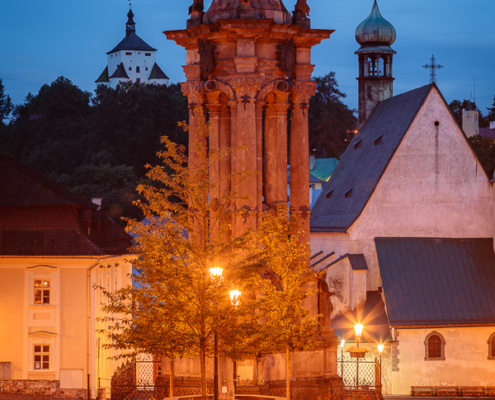 Holy Trinity Square in Banská Štiavnica during blue hour with illuminated Baroque plague column