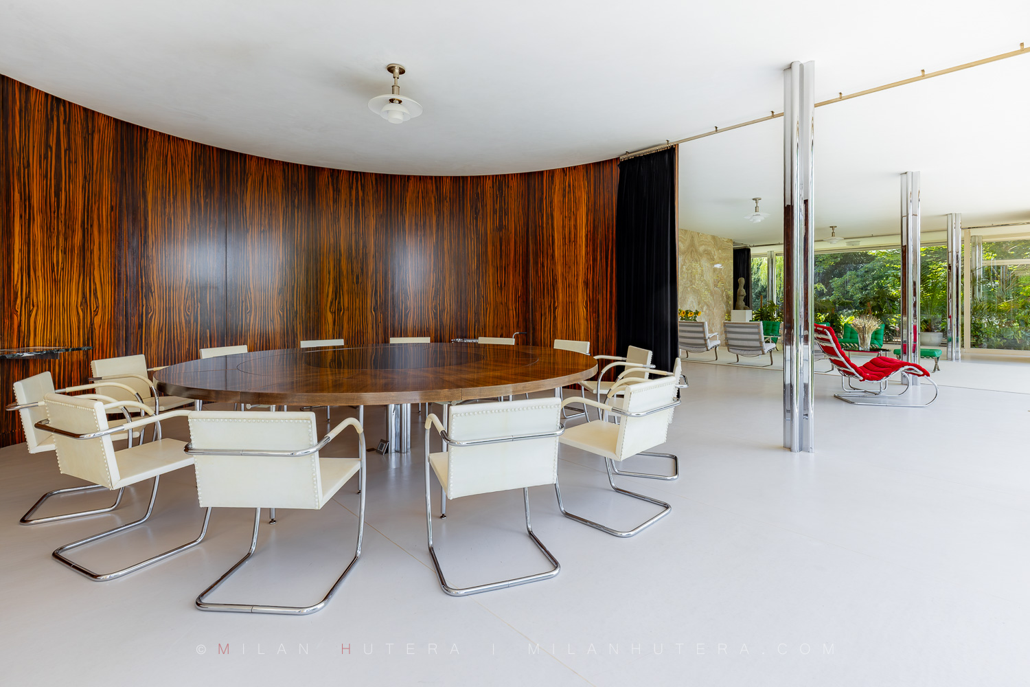 Villa Tugendhat dining area with curved Macassar ebony wall and white Brno chairs