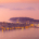 Primošten hazy sunset with the historic peninsula, harbour, Adriatic islands and smoke-softened pink evening sky